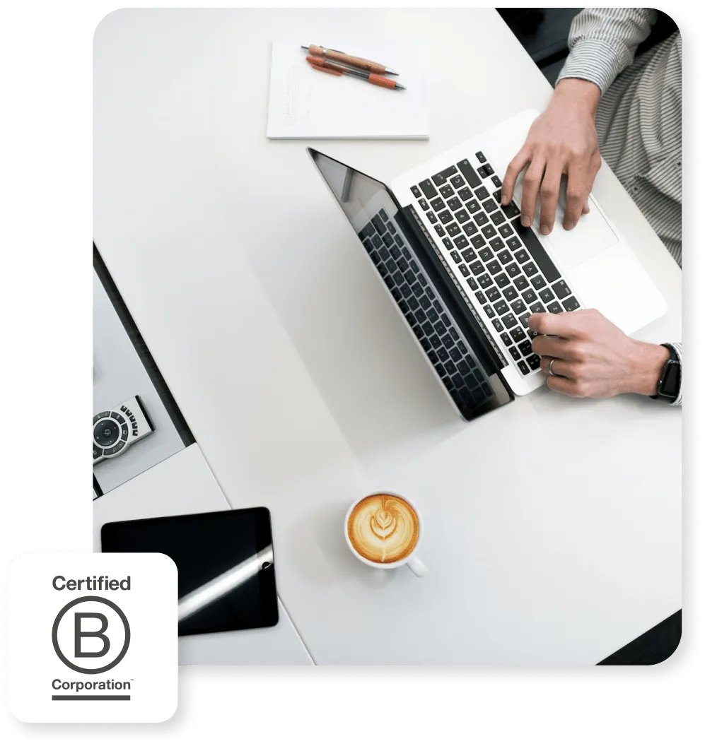 Person working on a laptop with coffee and tablet