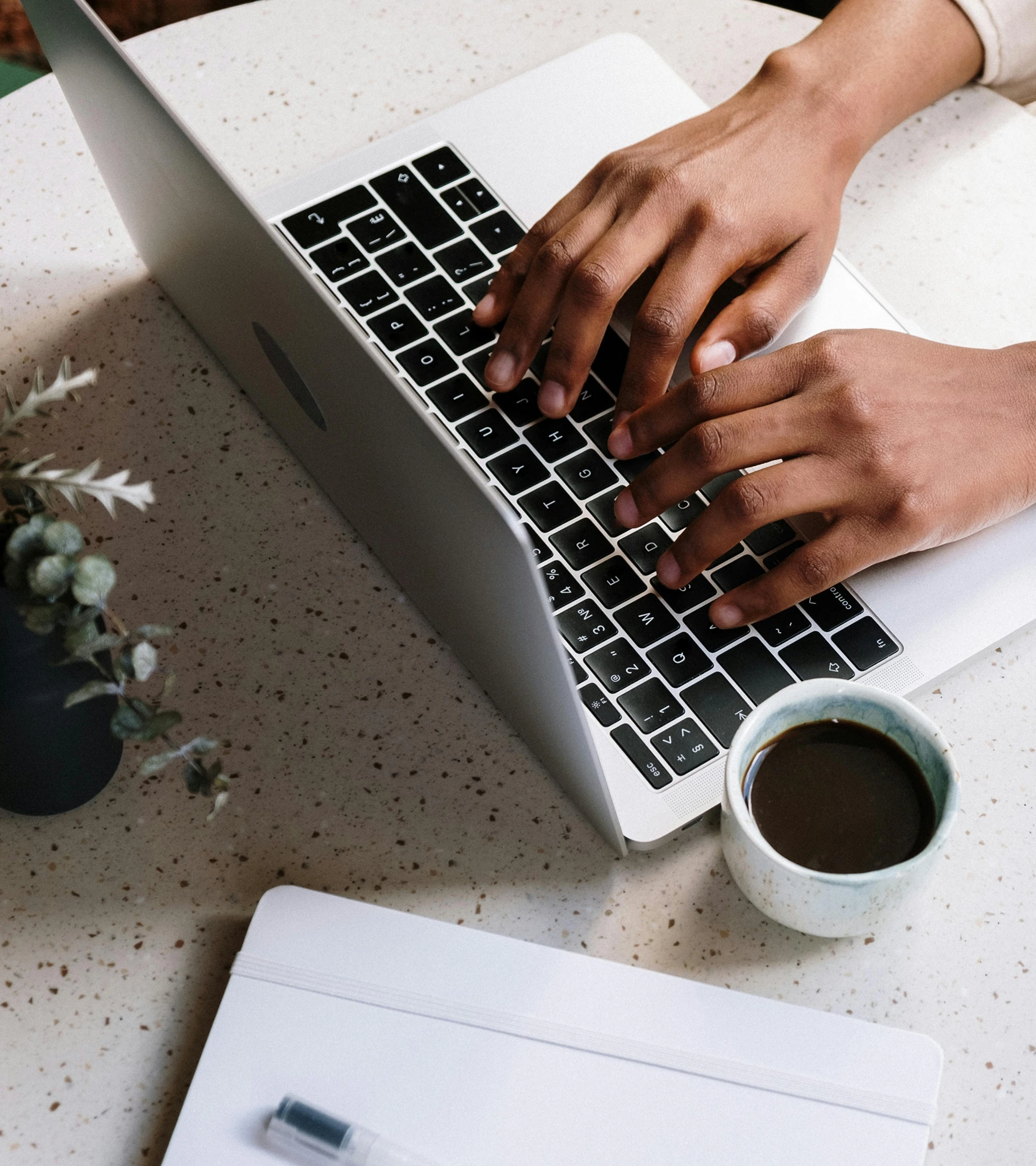 Person working on a laptop with coffee and tablet